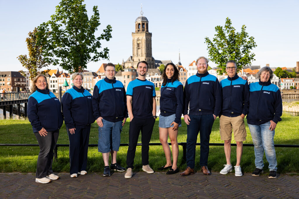 Het team van Wasconnect opgesteld in bedrijfskleding buiten op locatie